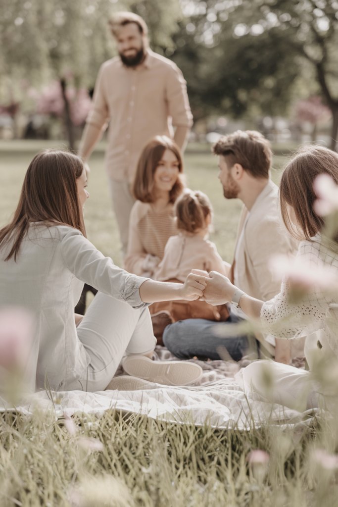 A family enjoying quality time in a sunny park surrounded by natural greenery.